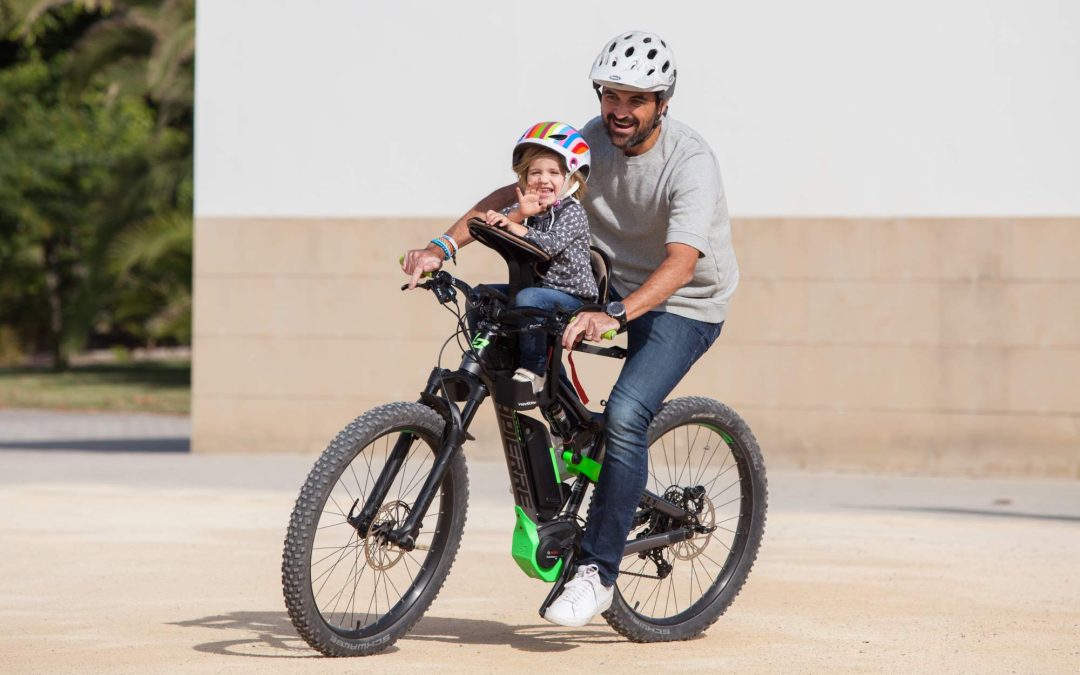 Father cycling with daughter in centre-mounted WeeRide bike seat on an electric bike