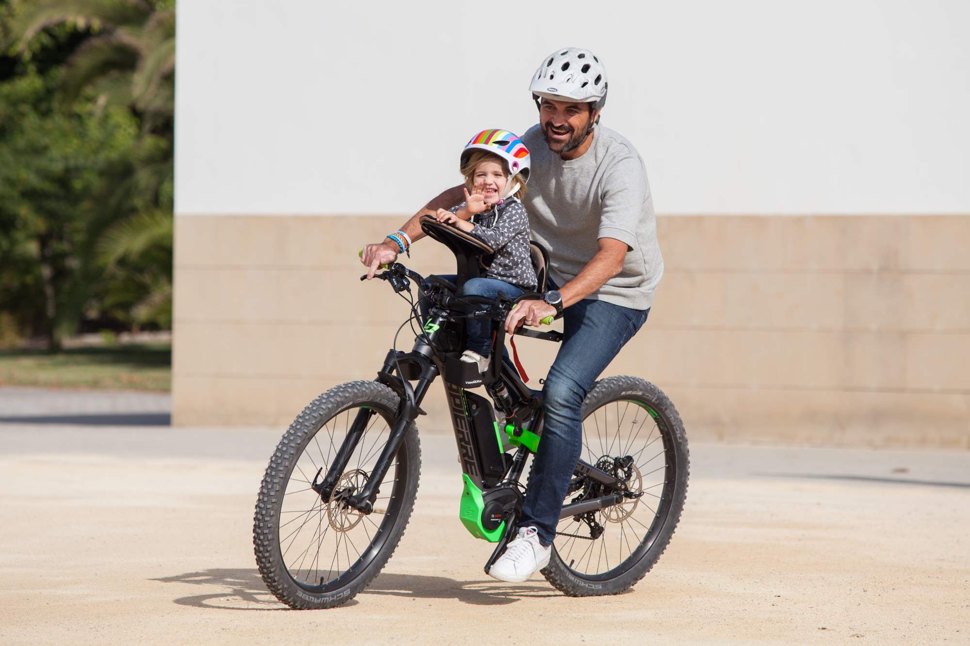 Father cycling with daughter in centre-mounted WeeRide bike seat on an electric bike