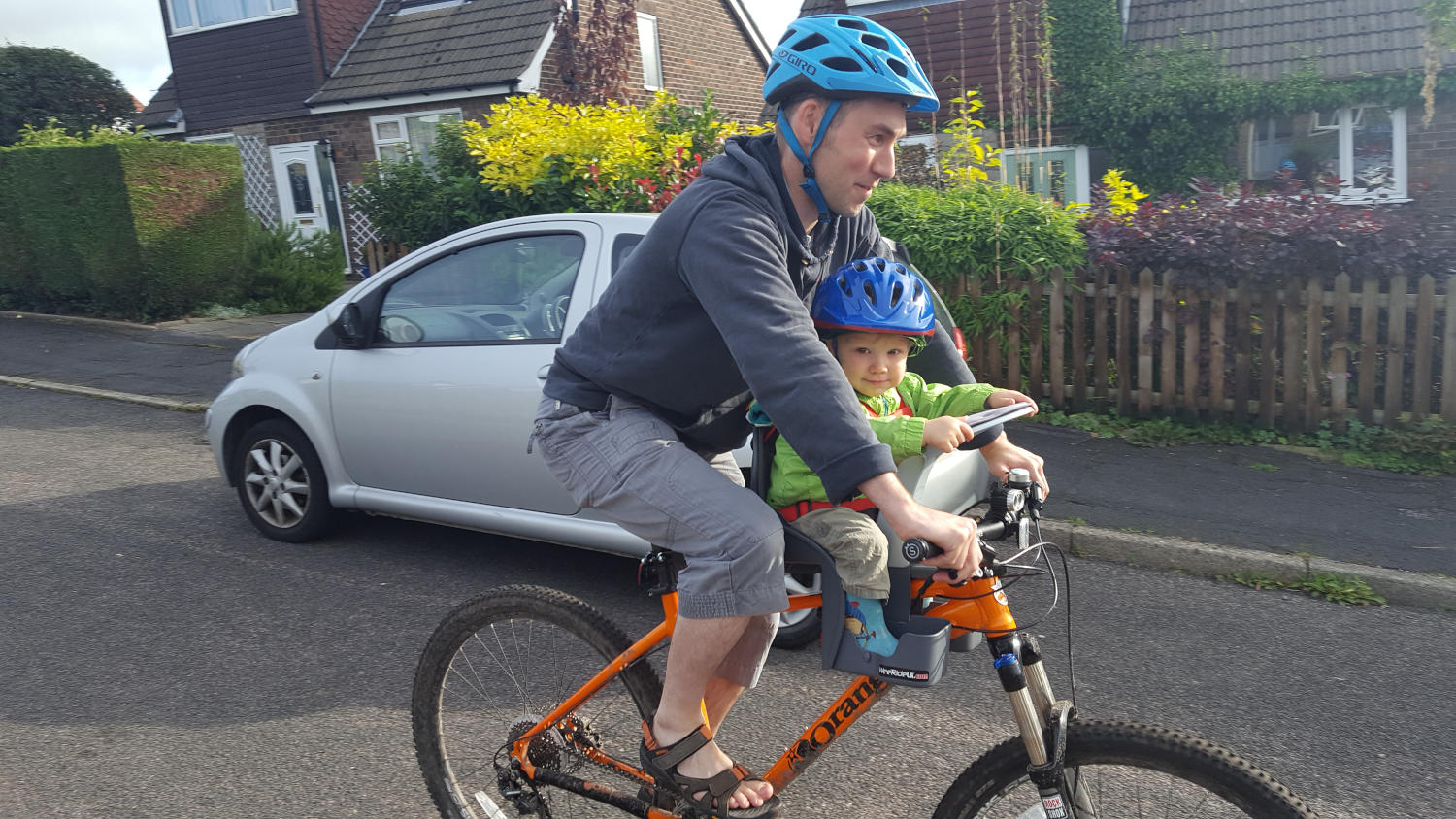 Parent cycling with child in a WeeRide Safe Front centre-mounted bike seat