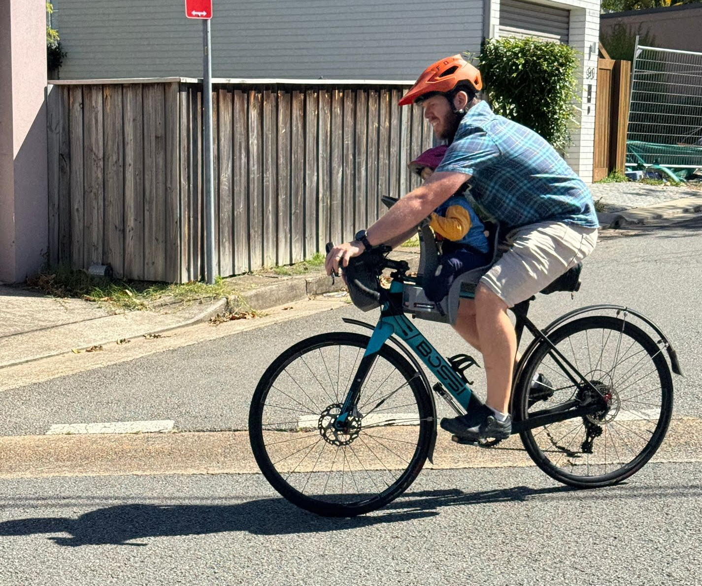 Riding with Son man on bike towing a child